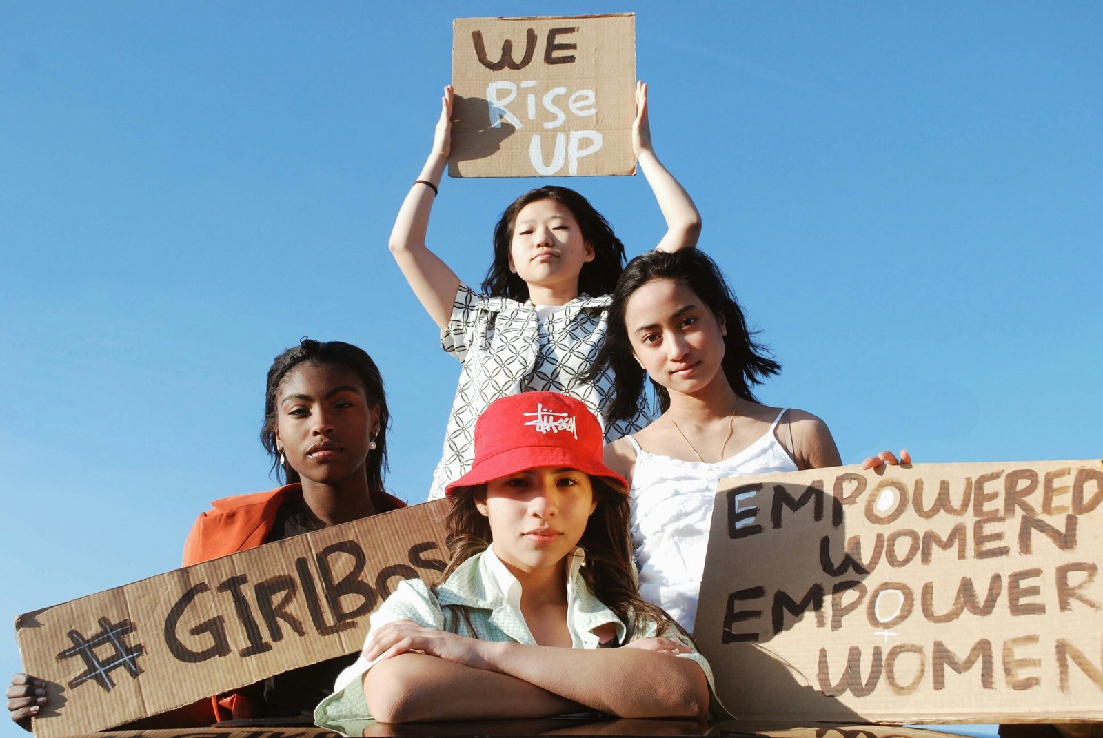 3 women holding brown cardboard box